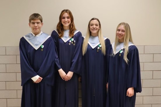 Four students in chorus robes