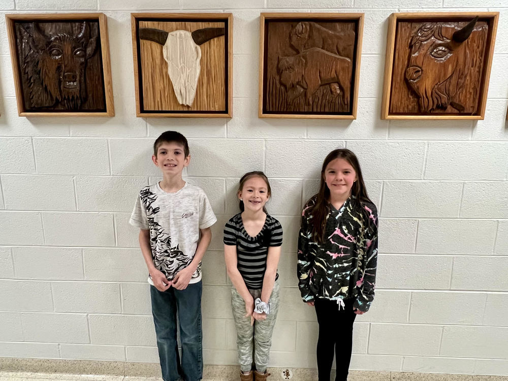 Three students standing by a wall who participated in Read-a-Thon